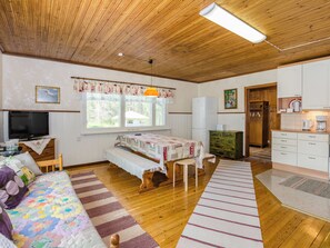 A cozy room with a bed, a sofa, a dining table, a television, and a kitchen area. - Vacation home Purola by Interhome (Polvijärvi)