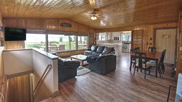 A cabin interior with a living area, kitchen, and dining space.