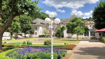 Un jardin bien entretenu, avec une grande variété de plantes et un lampadaire blanc au centre.