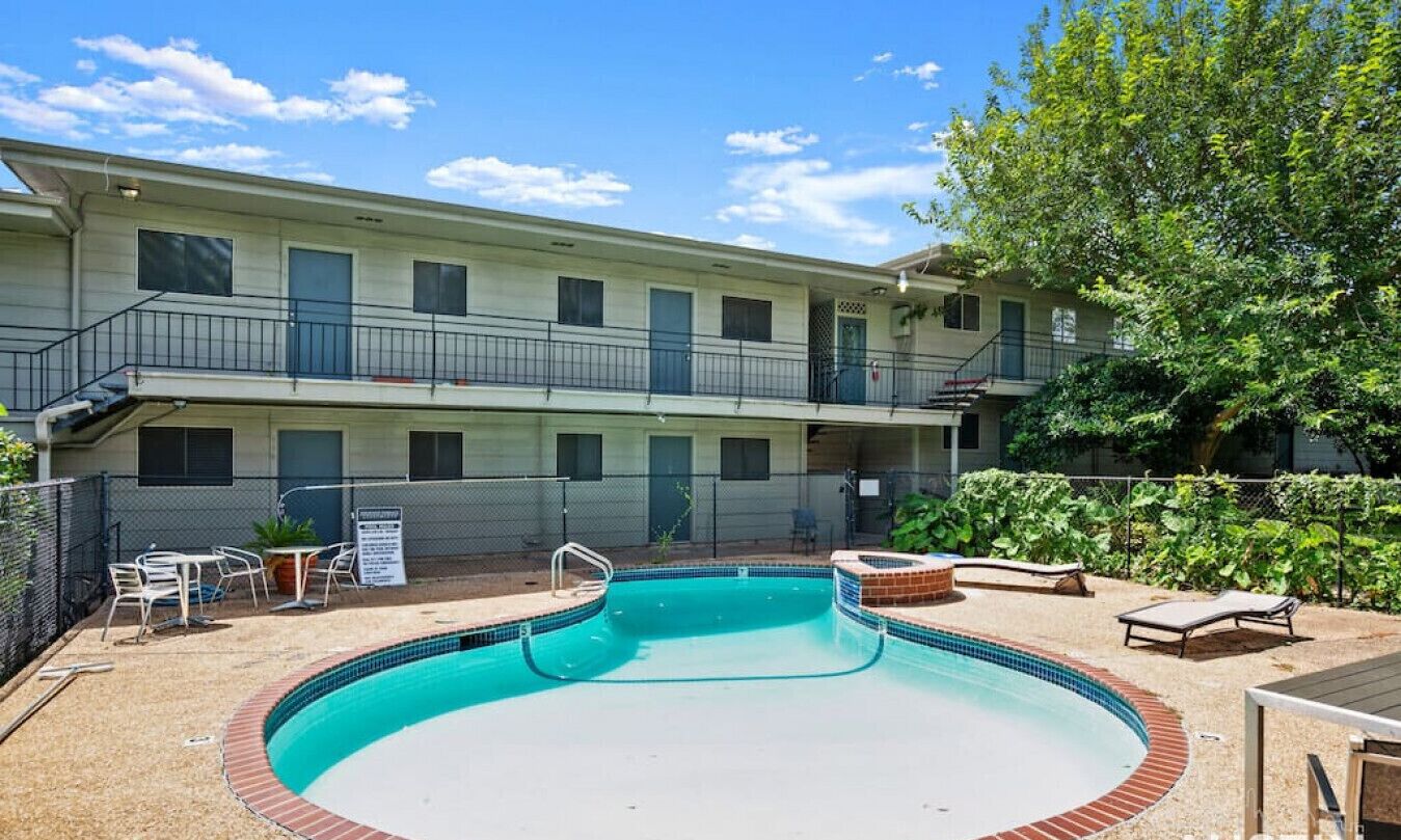 Un motel à deux étages doté d’une piscine, d’un espace extérieur aménagé et d’une cour clôturée.