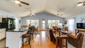 A spacious living area with a kitchen, dining area, and a large window. - Watts Bar Lake Escape: Private Boat Dock + Ramp! (Spring City)
