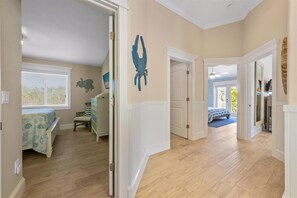 A hallway with a bed, dresser, and a door leading to another room. - Big Family Beach House: Large family home, heated pool, putting green (Anna Maria)