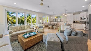 A spacious living area with a sofa, a coffee table, and a dining table.