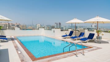 Una piscina al aire libre, tumbonas