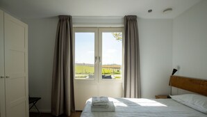 Une chambre à coucher comprenant un lit, une table de chevet, une chaise et une armoire.