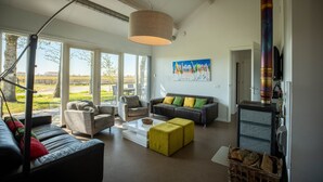 Un salon moderne avec un canapé, des fauteuils, une table basse et une cheminée.