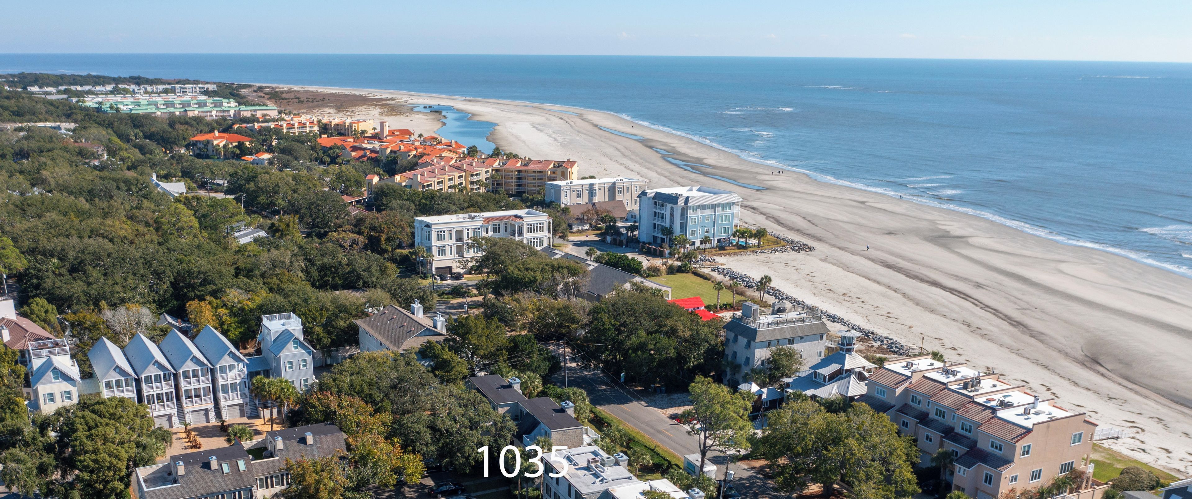 Ein Luftbild einer Küstenwohngegend mit Strand, einschließlich eines Gebäudes mit der Aufschrift '1035 Beachcomber'.