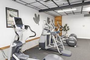 Ein Fitnessraum mit mehreren Laufbändern, Crosstrainern und einem Ergometer.