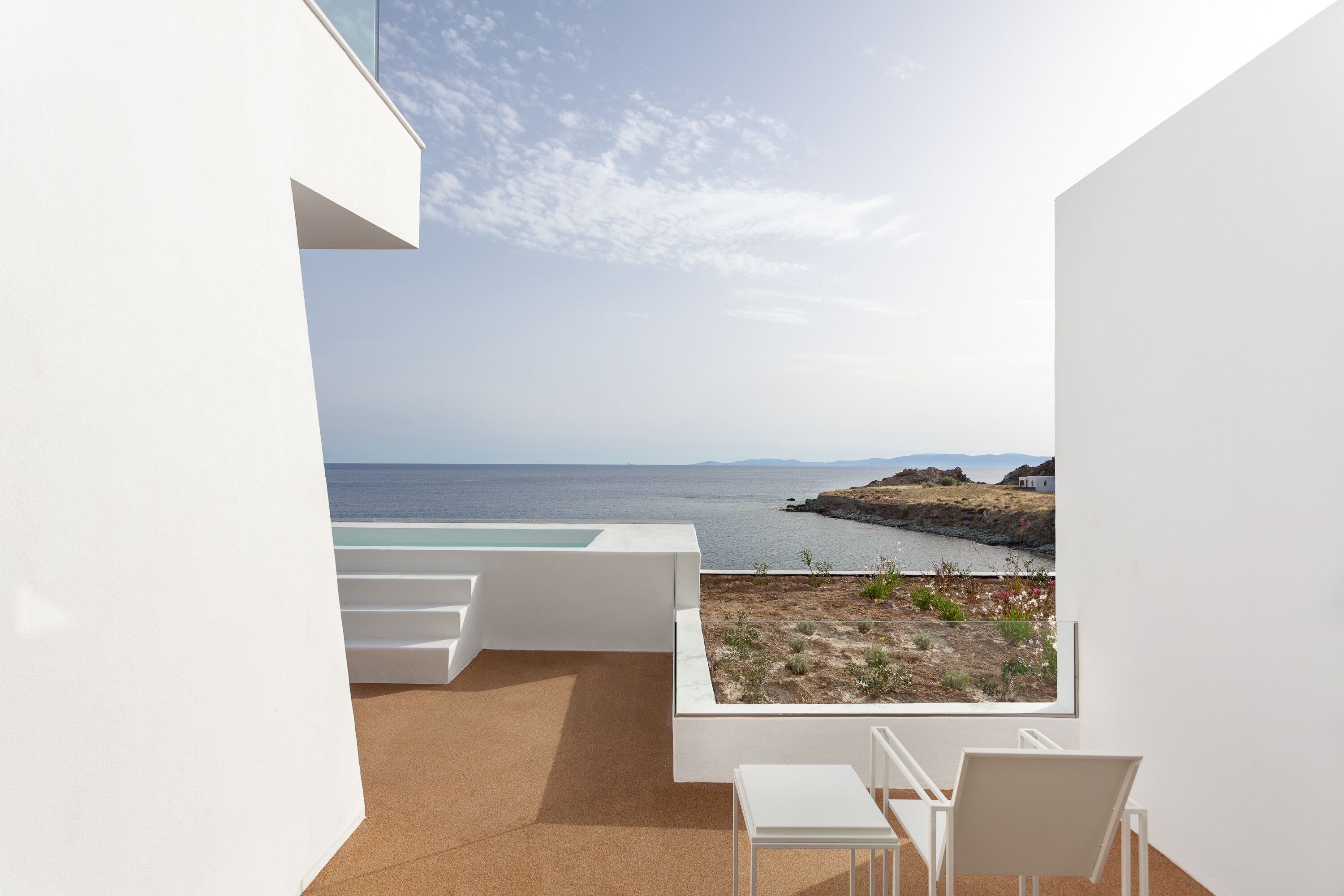 Ein moderner Balkon mit Blick auf das Meer und eine felsige Küstenlandschaft.