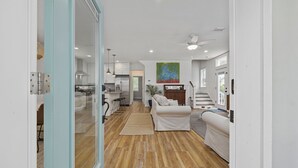 A spacious living area with a kitchen, a dining area, and a staircase leading to another level.