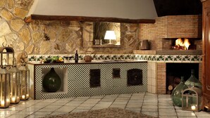 A rustic kitchen with a stone wall, a brick fireplace, and a checkered tile backsplash. - Beautiful private villa with A/C, private pool, WIFI, TV, patio, panoramic view, close to Sorrento (Sant'agata Sui Due Golfi)