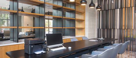 A modern office space with a long table, multiple chairs, and a printer.