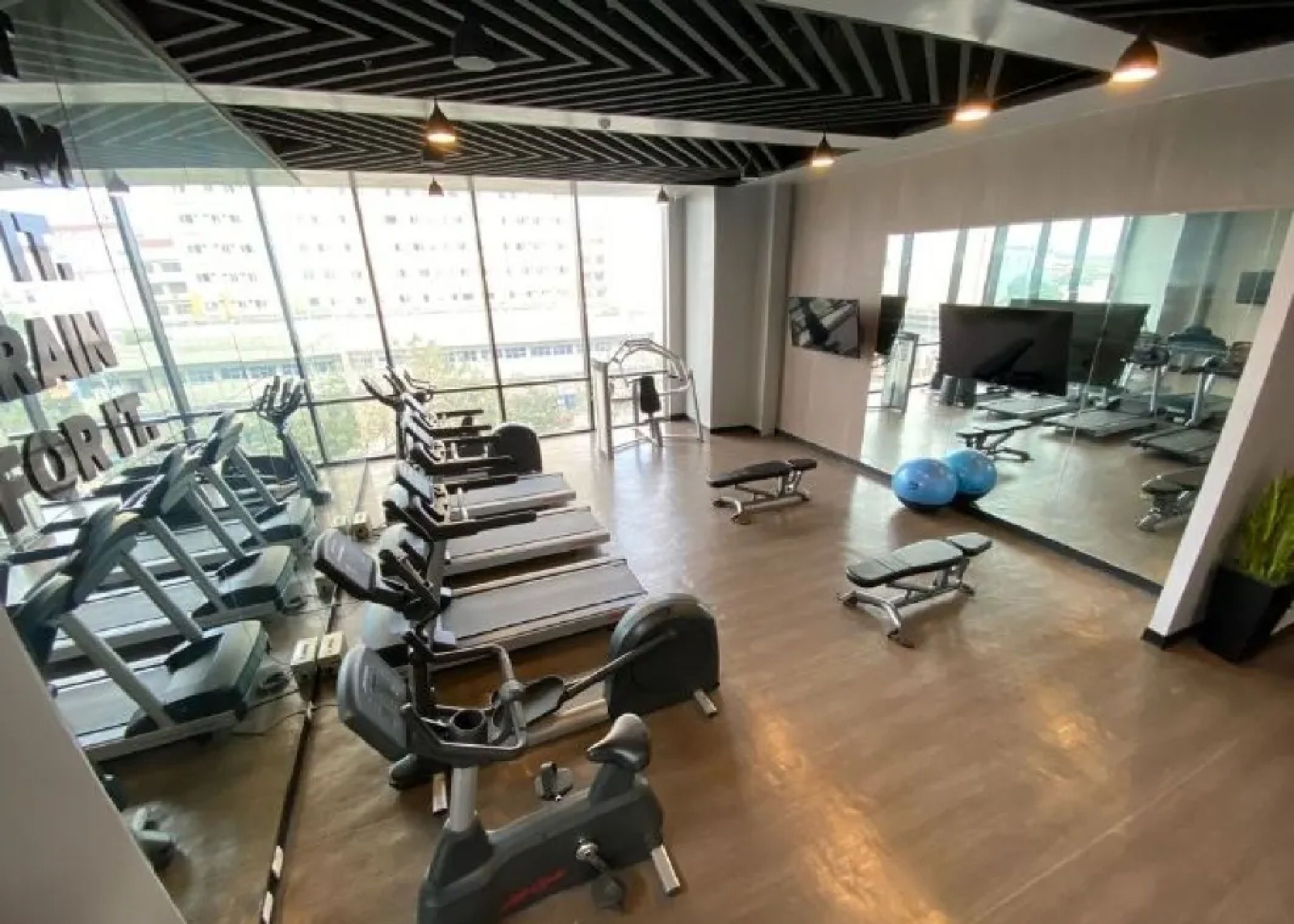 A gym with treadmills, weight machines, and exercise balls.