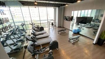 A gym with treadmills, weight machines, and exercise balls.