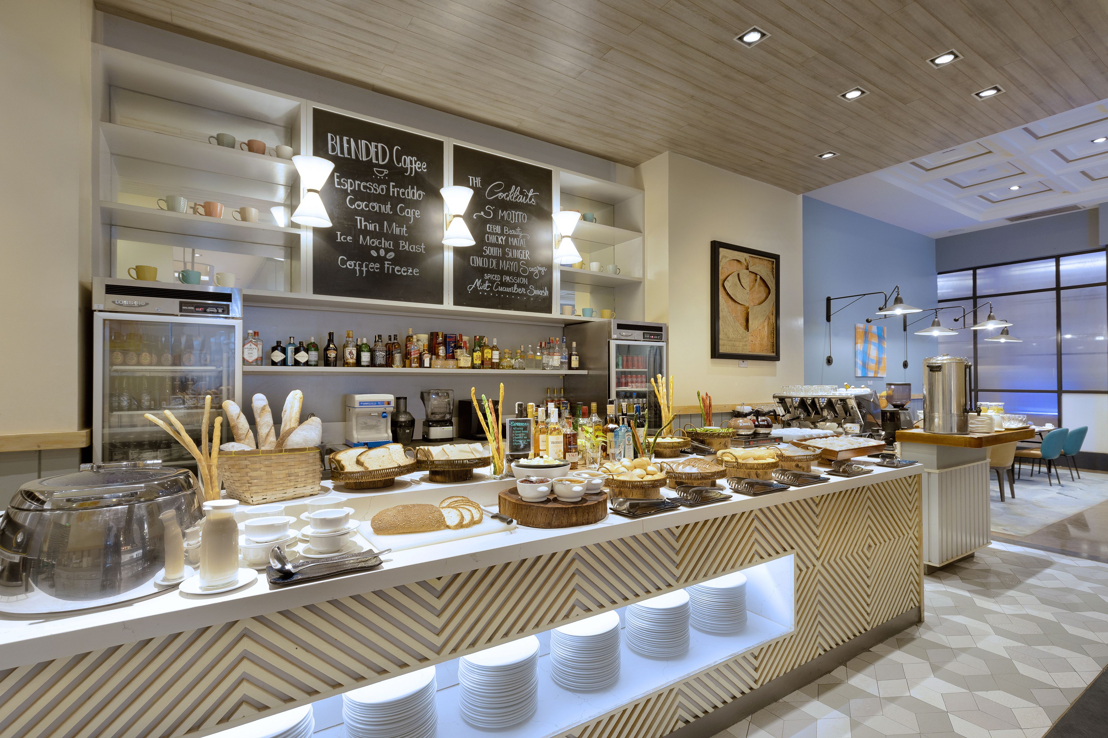 A buffet area with a variety of food and drink options, including a coffee station and a selection of beverages.
