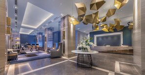 A modern hotel lobby with a reception desk, seating area, and unique geometric light fixtures. - Summit Galleria Cebu (Cebu City)