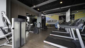 A gym with treadmills, elliptical machines, and weight equipment.