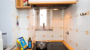 A kitchen with a stove, a pot, a bag of pasta, and a bottle of olive oil. - Accogliente (Roma)