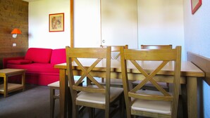 A dining area with wooden chairs and a red sofa. - At the foot of the Slopes (La Plagne-Tarentaise)