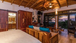 Une chambre spacieuse avec un grand lit, des meubles en bois et une vue sur l’extérieur.