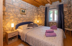 Relax in this serene bedroom with a large bed, bedside tables, and a window with curtains.
