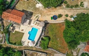 Surrounded by lush greenery, this property offers a swimming pool, covered patio, and play area.