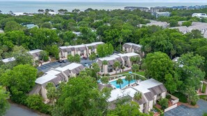 Un quartier résidentiel composé de plusieurs immeubles à deux étages, doté d’une piscine et offrant une vue sur l’océan.