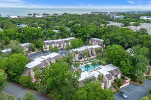 Un quartier résidentiel composé de plusieurs immeubles à deux étages, doté d’une piscine et offrant une vue sur l’océan.