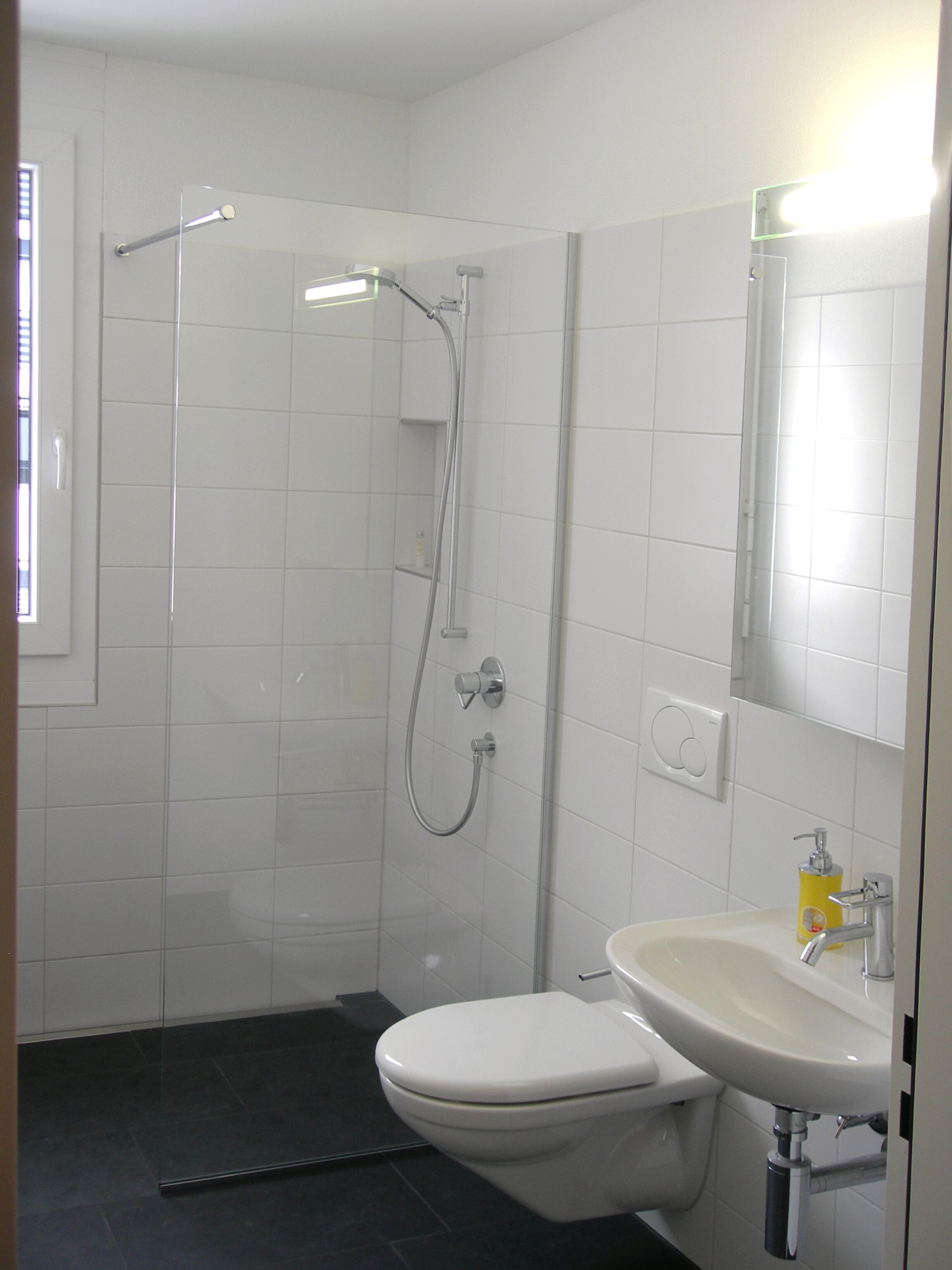 Ein Badezimmer mit Dusche, Toilette und Waschbecken.
