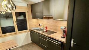 Una cucina moderna con piano di lavoro in legno, lavello in acciaio inossidabile e macchina per caffè espresso integrata.