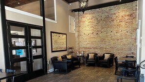 A cozy interior with a brick wall, leather chairs, and a wooden floor. - Park Hotel (Clarkdale)