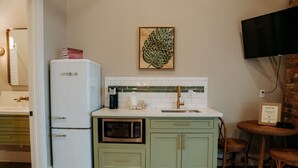 A compact kitchen with a refrigerator, microwave, and a small sink.
