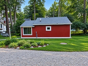 A red single-story house with a sloped roof, a small window, and a chimney.