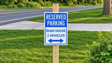 A reserved parking sign for a road house with a capacity for 2 vehicles.