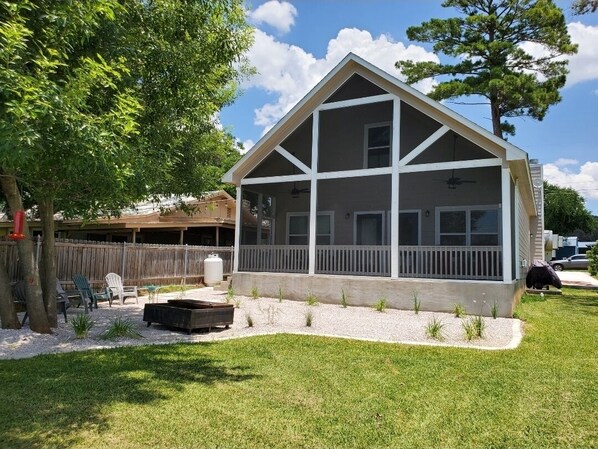 Situated in a serene yard, this charming home features a covered porch and a well-manicured lawn.