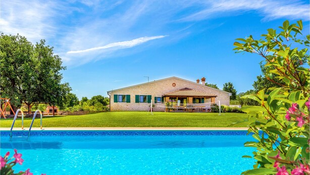 Une maison avec une piscine, une terrasse et un jardin.
