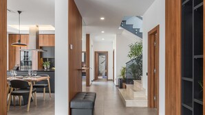 Un interior moderno con comedor, cocina y escalera.