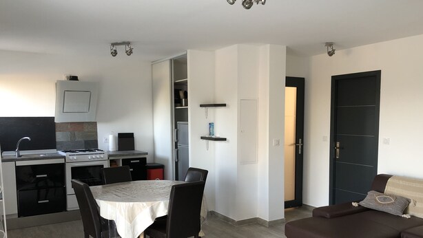 A compact living space with a kitchenette, dining area, and a sofa. - U PRIMU - Spacious, quiet apartment Aléria (Aléria)