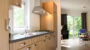 Una cucina moderna con mobili in legno, un lavello in acciaio inossidabile e un piano cottura a gas.