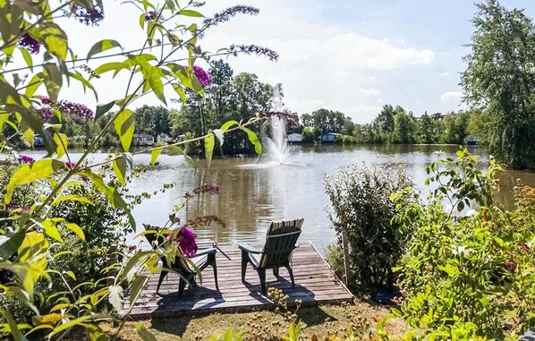 Relax on the lakeside dock, surrounded by lush greenery and a soothing fountain.