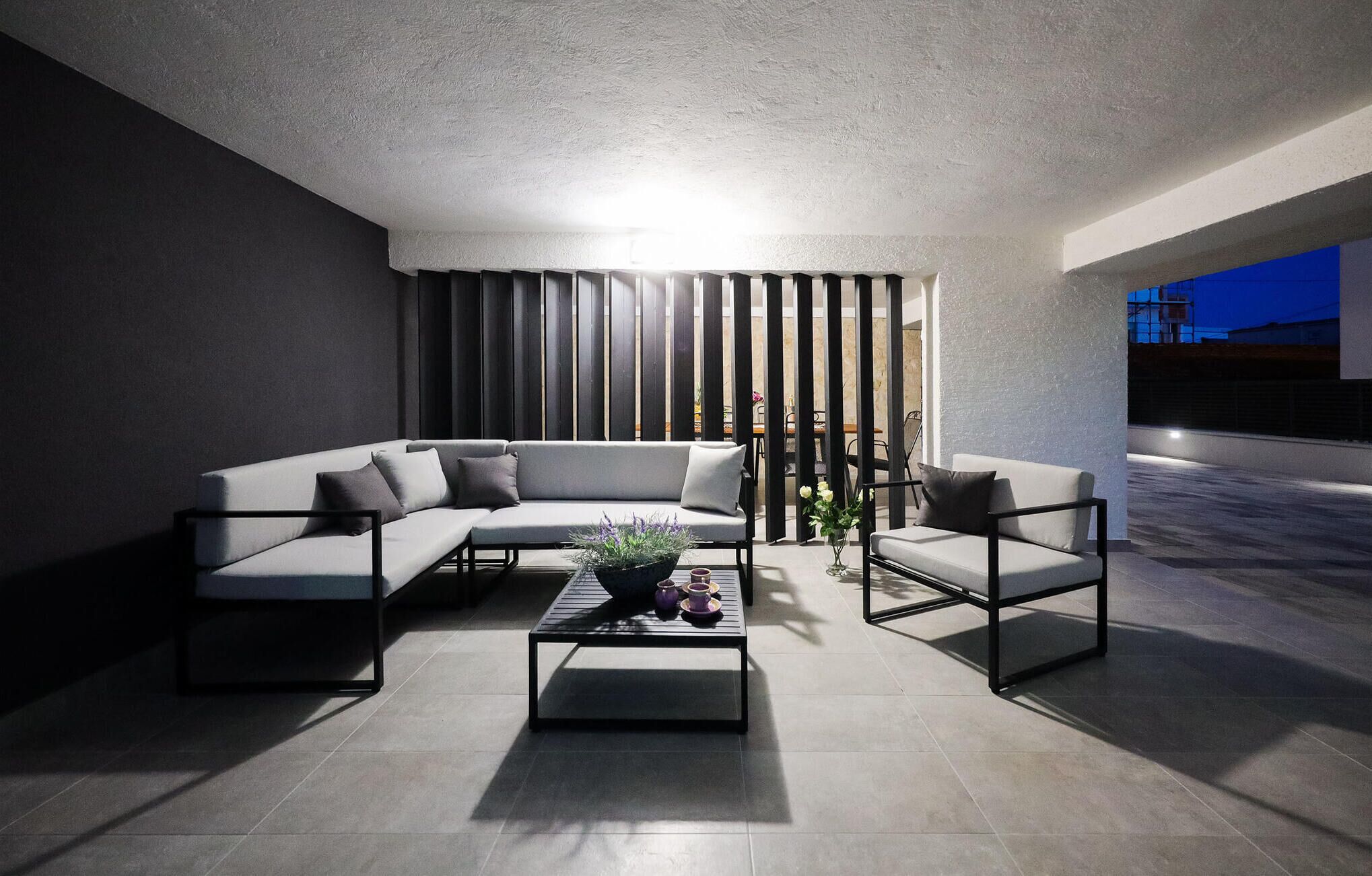 Una sala de estar moderna con un sofá modular, una mesa de centro y un sillón.