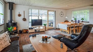 A cozy living room with a fireplace, a TV, and a dining area with a table and chairs. - Cozy home in Vinderup with WiFi (Vinderup)