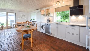A modern kitchen with a brick floor, wooden ceiling, and white cabinetry. - Cozy home in Vinderup with WiFi (Vinderup)