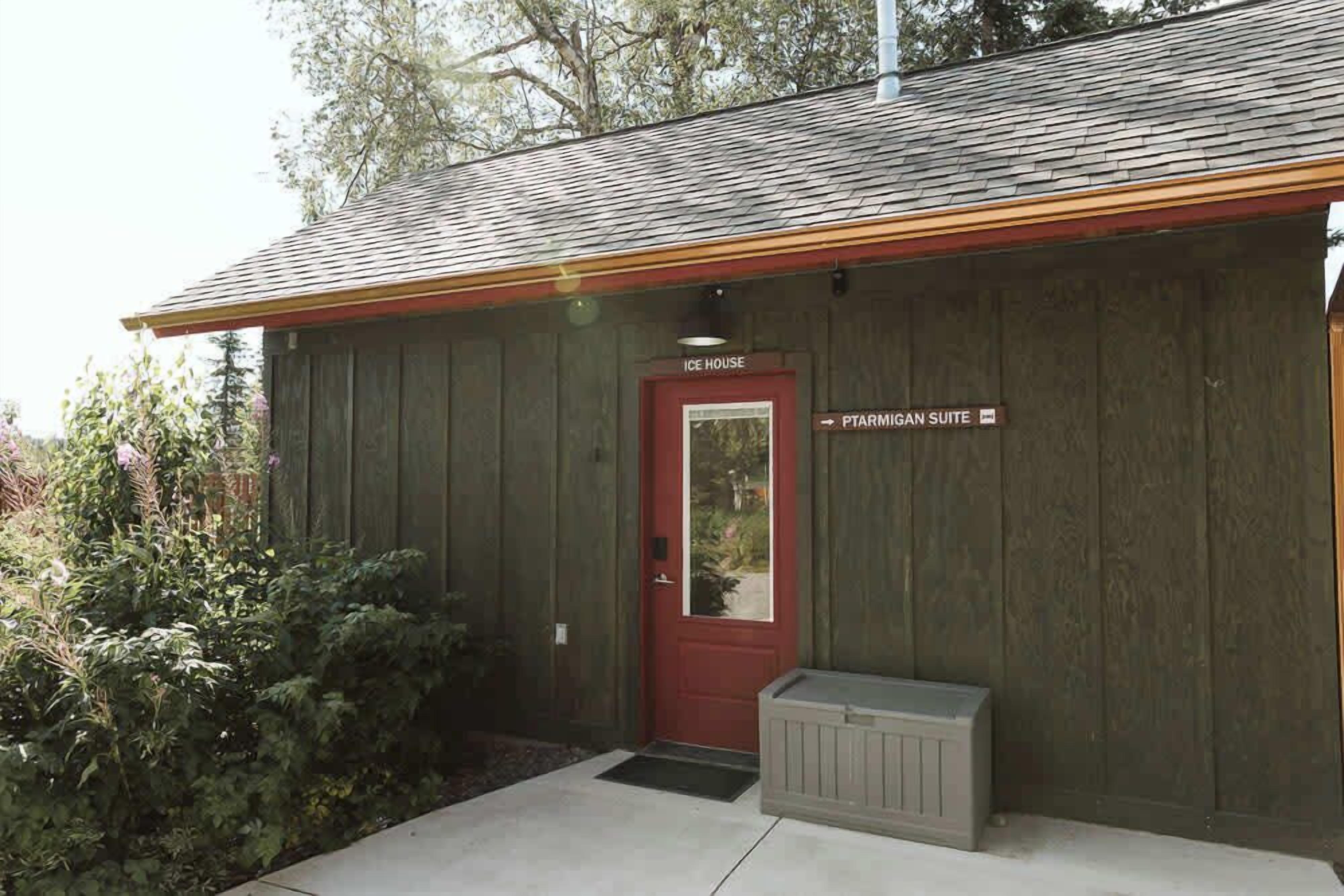 A wooden building with a red door labeled "Ice House" and "PTARMIGAN SUITE."
