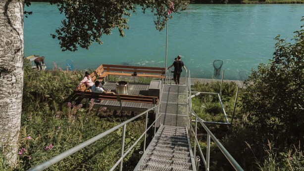 Un pontile in legno con una scala in metallo che conduce a un fiume.