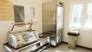 Una cucina con frigorifero in acciaio inox, un alimentatore caldo e un cestino per i rifiuti.