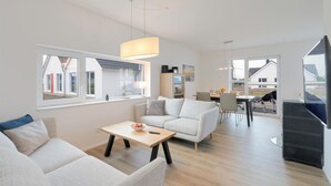 Uma sala de estar moderna com sofá, mesa de centro e espaço de jantar.