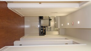 A narrow hallway with a wooden ceiling and white walls, leading to a kitchen area with modern appliances and recessed lighting. - Amazing 3 bedrooms Apartment Yonge/Finch/Sheppard. 10 mins walking to Subway sta (Toronto)