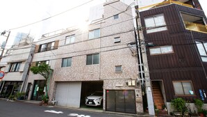 A multi-story residential building with a garage door open, revealing a parked car. - Hakuro Skytree (Tokyo)