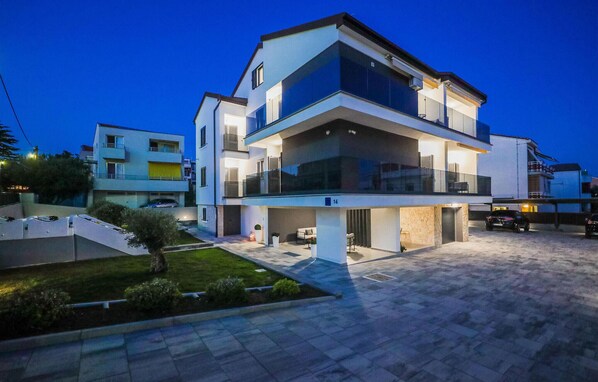 A modern two-story residential building with a flat roof, large windows, and a balcony. - Nice apartment in Zadar with heated swimming pool (Zadar)